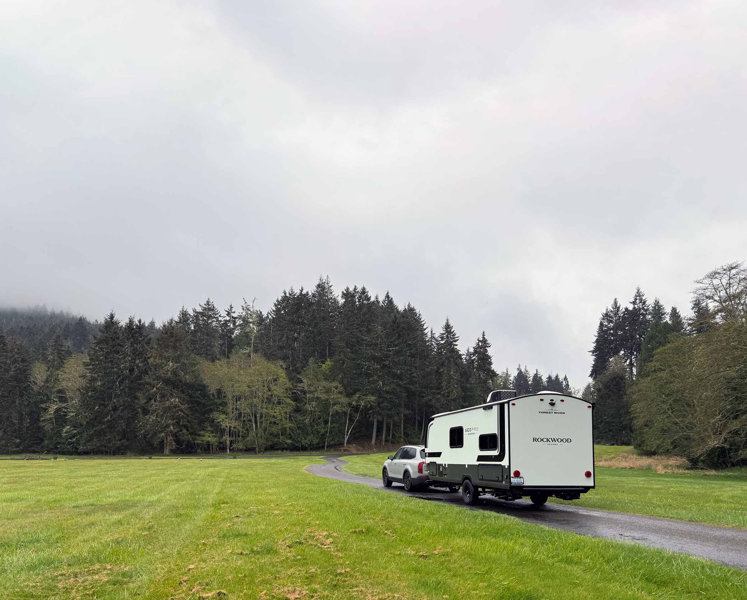 Truck towing a Rockwood trailer along a winding road through Capitol Forest, WA